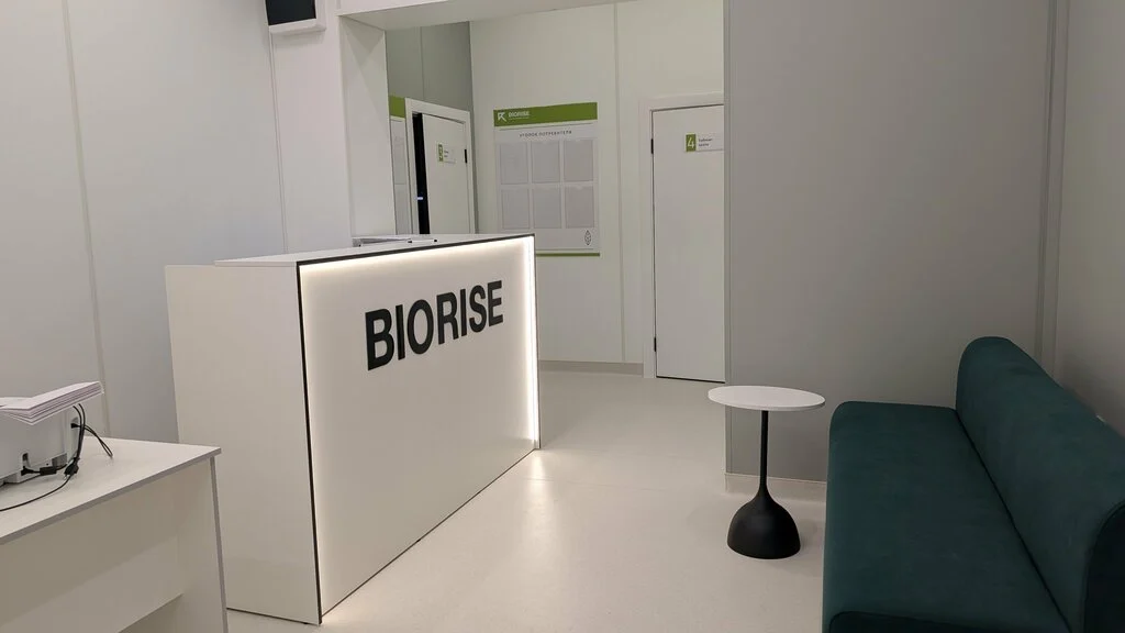 Ресепшен BIORISE на Дыбенко: стойка с логотипом и зона ожидания